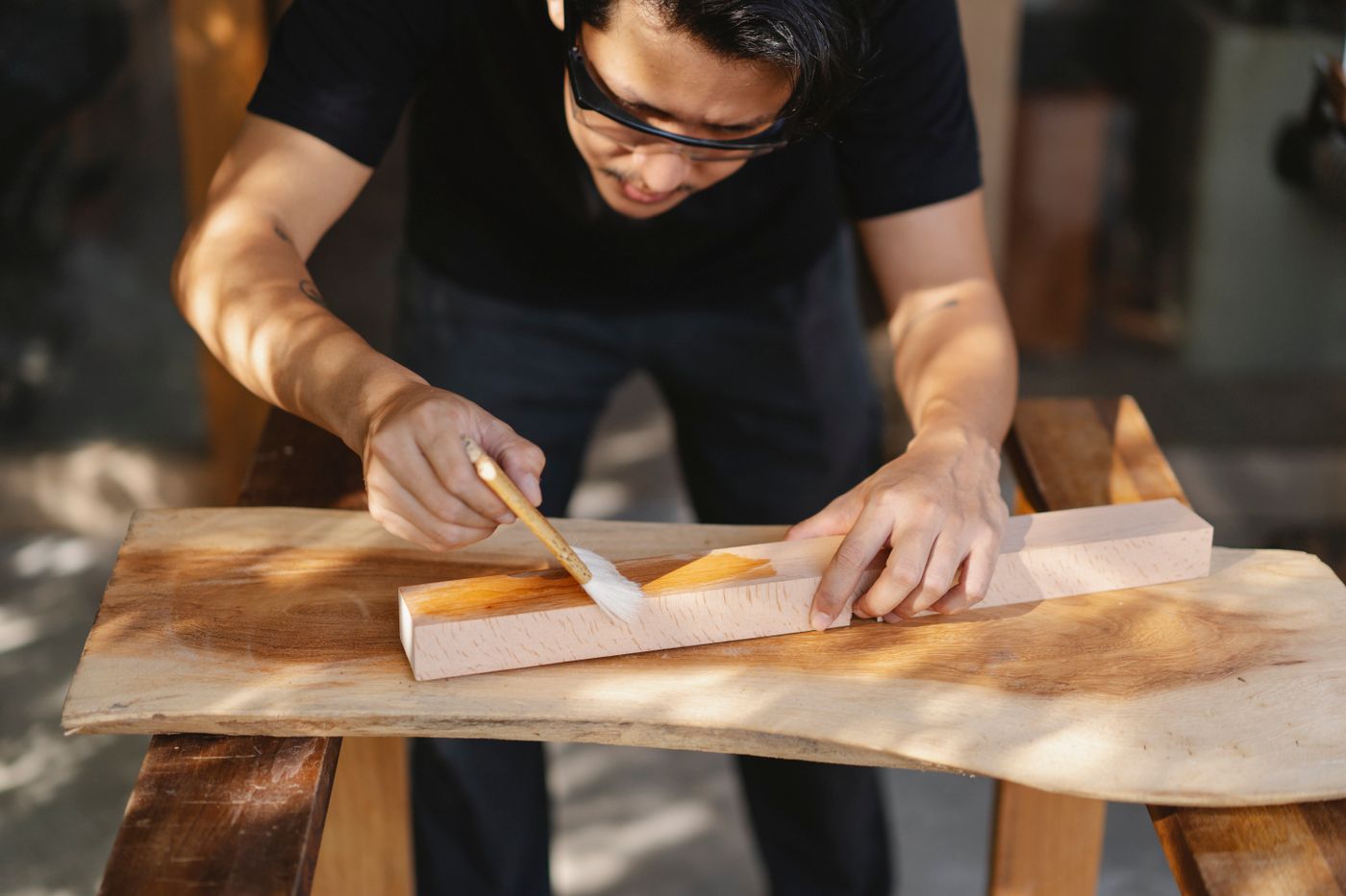 Aplicación de barniz sobre madera en taller